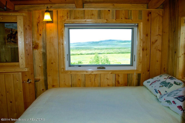 Charming little bedroom in tiny house log cabin for sale in Wyoming