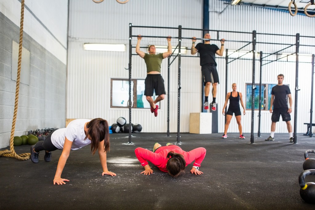 Group of male and female athletes exercising in gym
