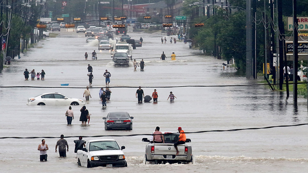 People walk through the flooded waters of Telephone Rd. in Houston as the fourth largest city in the U.S. battles Tropical Storm Harvey and resulting floods.