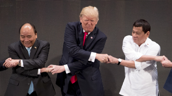 President Trump does the "ASEAN-way handshake" with Vietnamese Prime Minister Nguyen Xuan Phuc (left) and Philippines President Rodrigo Duterte on stage during the opening ceremony at the ASEAN Summit on Monday. Trump initially did the handshake incorrectly.