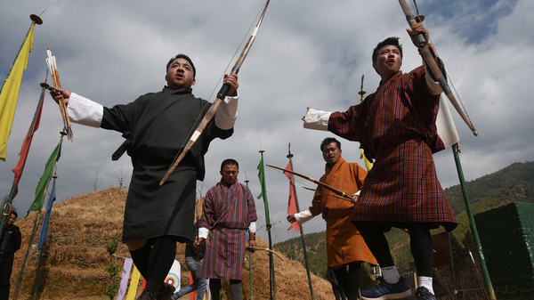 Archers indulge in a raucous competition, cheering teammates and jeering opponents. Here archers celebrate with a ritual victory dance after a teammate hit the narrow target.