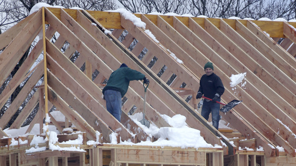 Men shovel snow off the top of a building under construction in Franklin Lakes, N.J., on Thursday. Job growth in February was led by a sharp increase in construction employment.