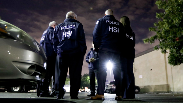 U.S. Immigration and Customs Enforcement agents gather before serving a employment audit notice at a 7-Eleven convenience store in Los Angeles in January.