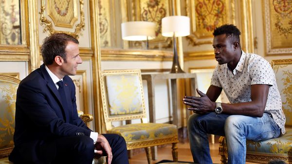 French President Emmanuel Macron speaks with Mamoudou Gassama at the presidential palace in Paris, on Monday. Macron offered Gassama citizenship for his "heroic act" in saving a four-year-old.