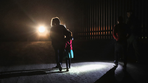 A Honduran mother walks with her children next to the U.S.-Mexico border fence as they turned themselves in to Border Patrol agents in February near Penitas, Texas.